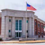 Front entry view of Snellville Police Station, from across Wisteria Road; showing the american flag and police department sign