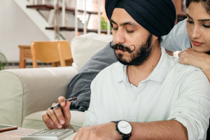 Couple looking down at calculator and writing notes